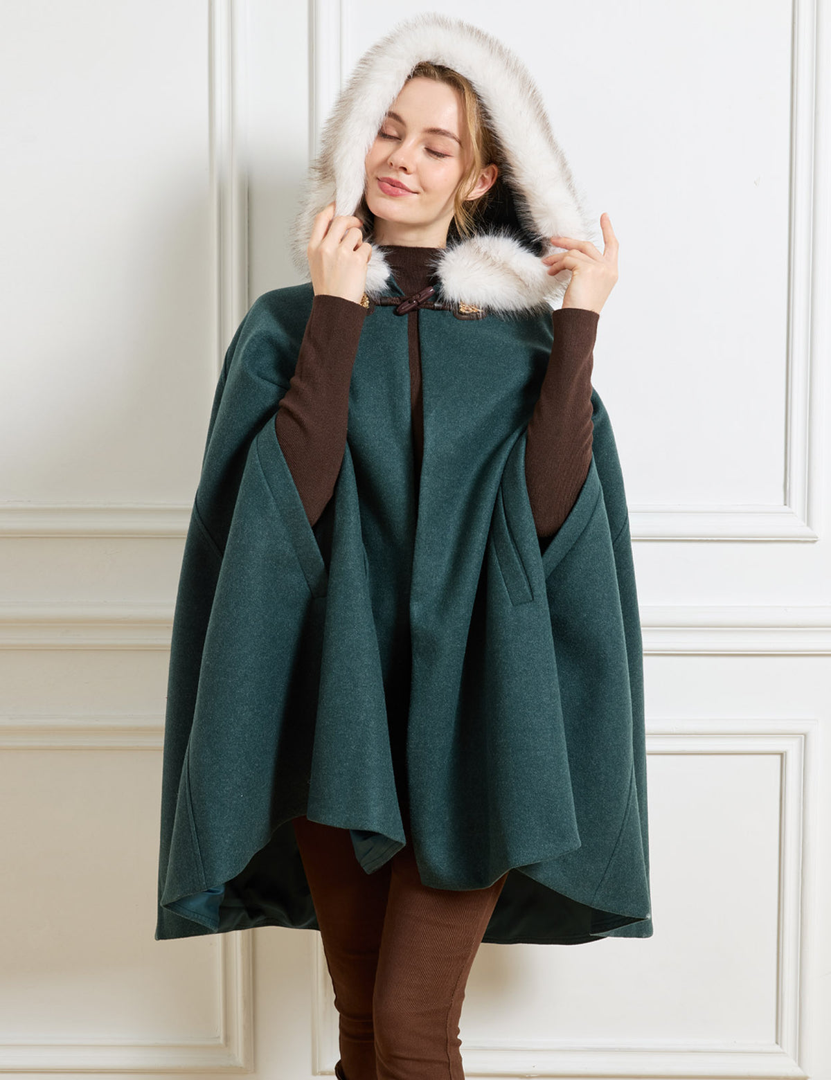 Beautelicate forest green vintage inspired cloak in a cozy wool blend, featuring an oversized faux fur hood and open A-line cut, perfect for comfortable and effortless winter layering.