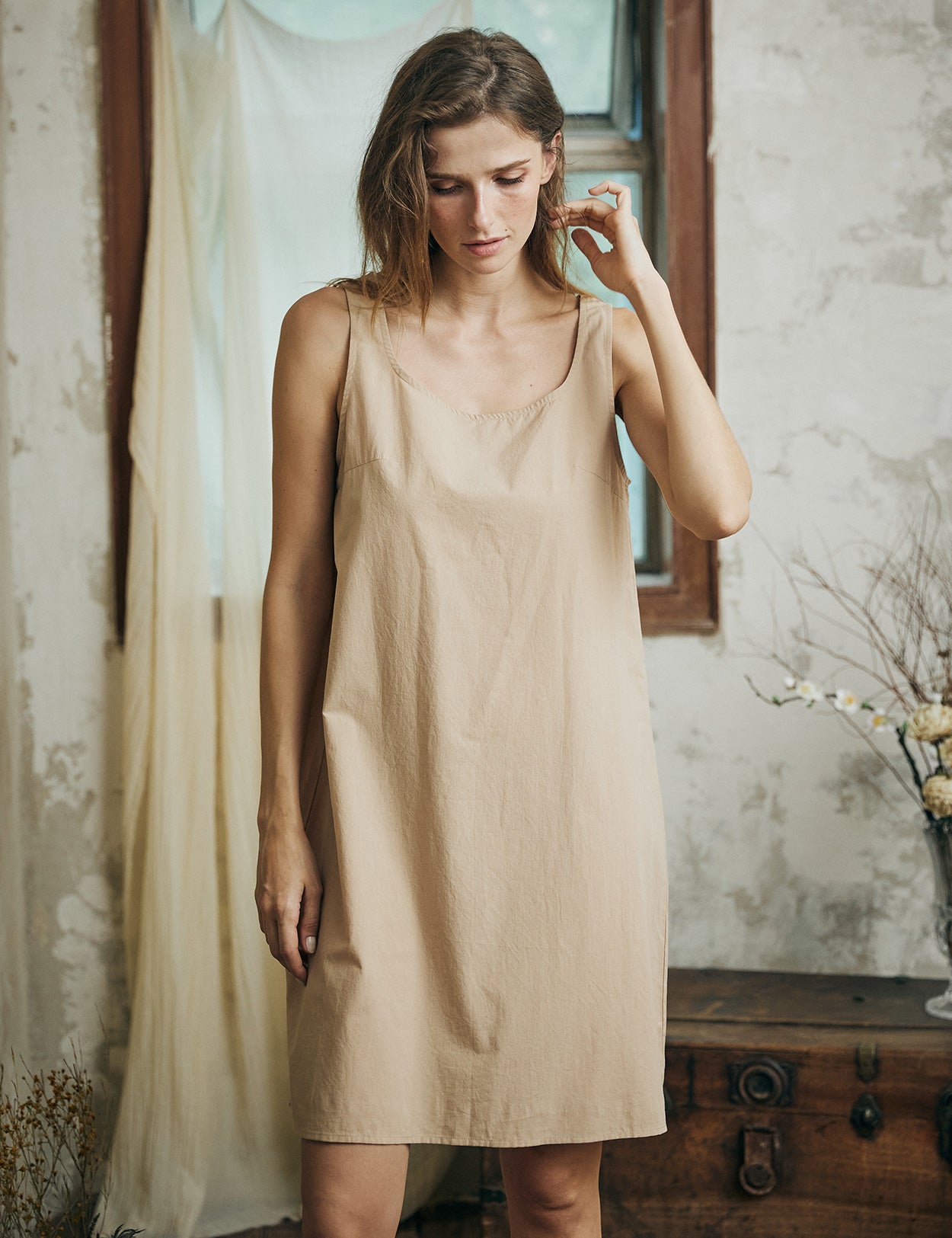 Woman wearing nude cotton full slip with wide straps, showing comfortable fit and elegant design