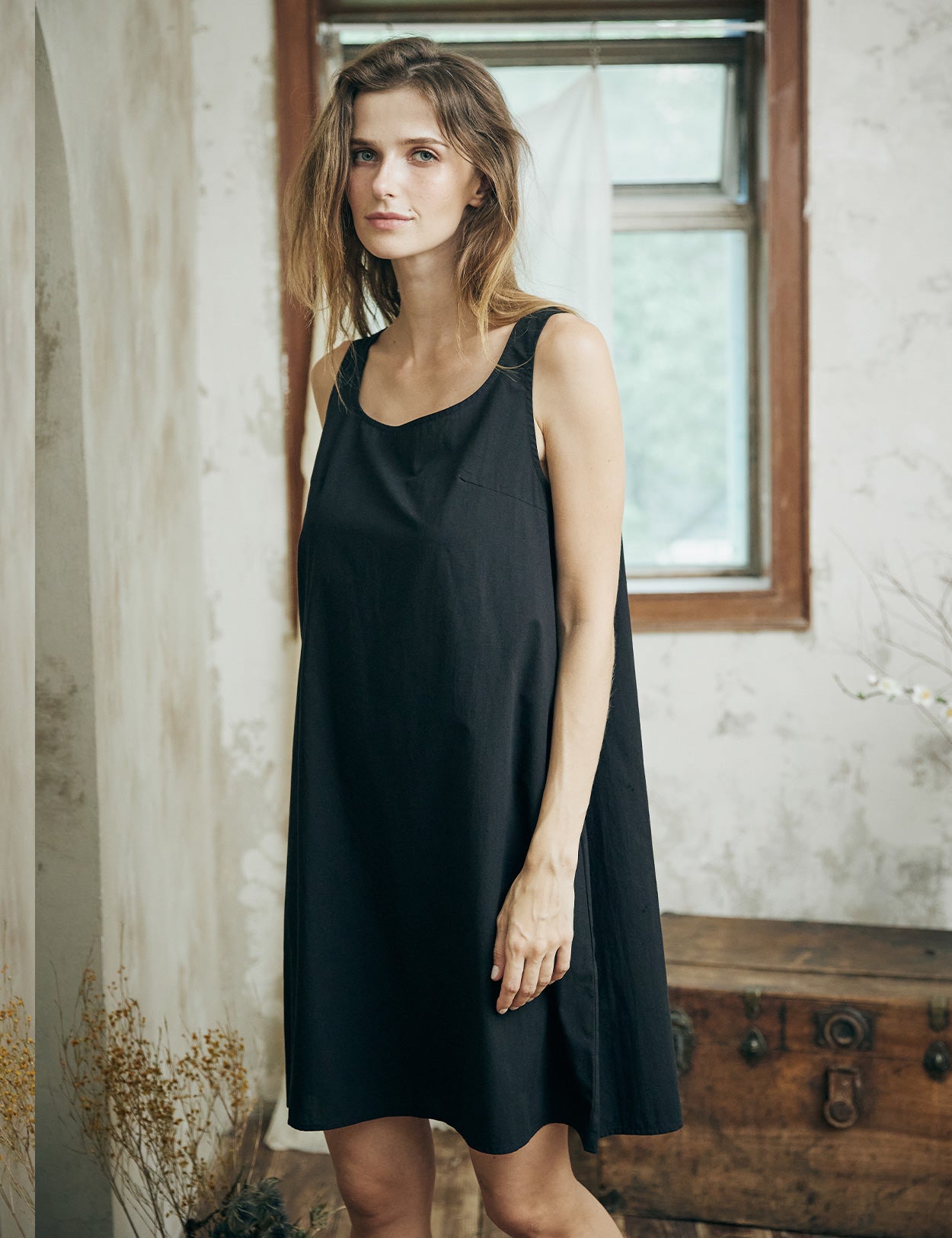 Woman wearing black cotton full slip with wide straps, showing comfortable fit and elegant design