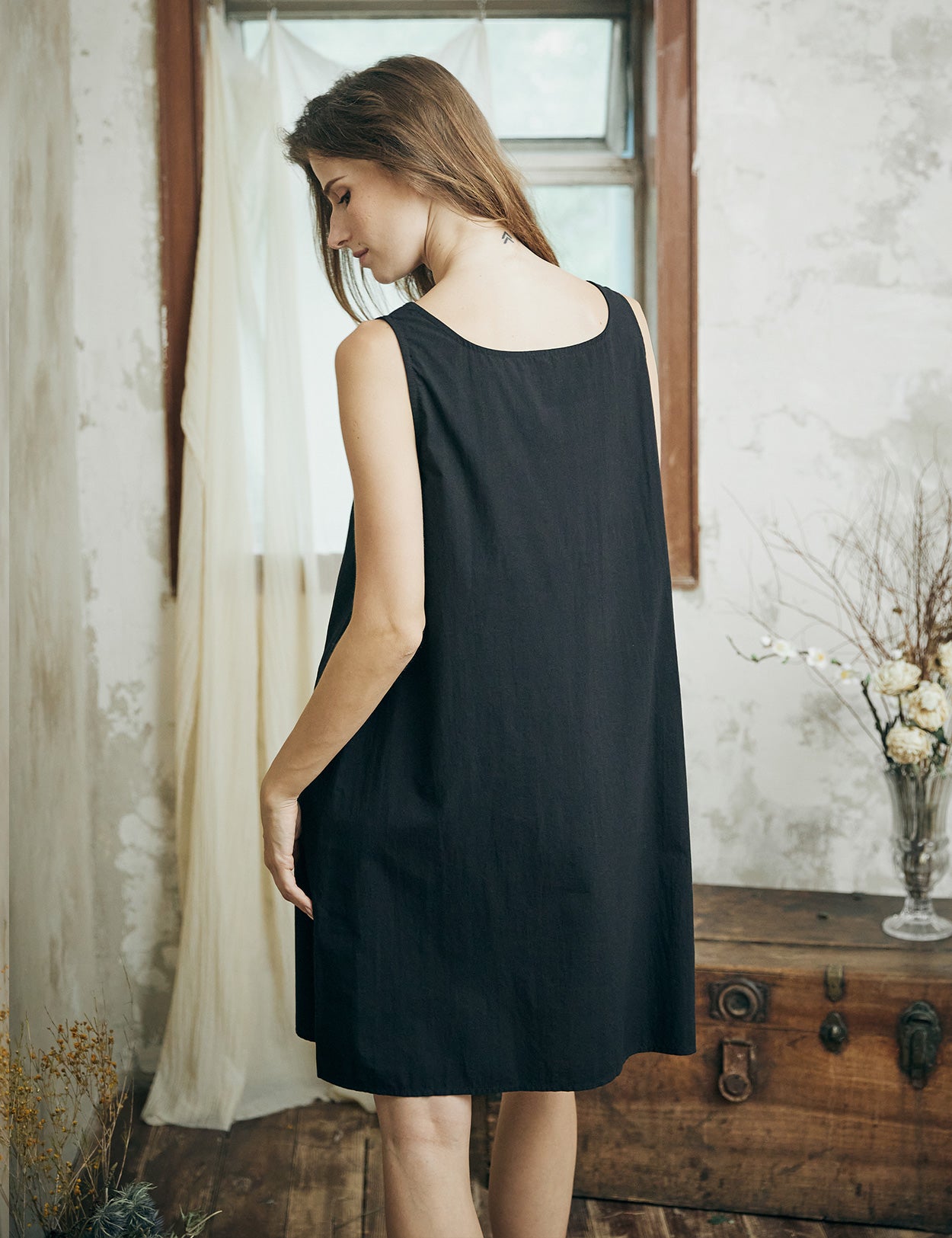 Back view of black cotton full slip displaying the flowing silhouette and comfortable fit