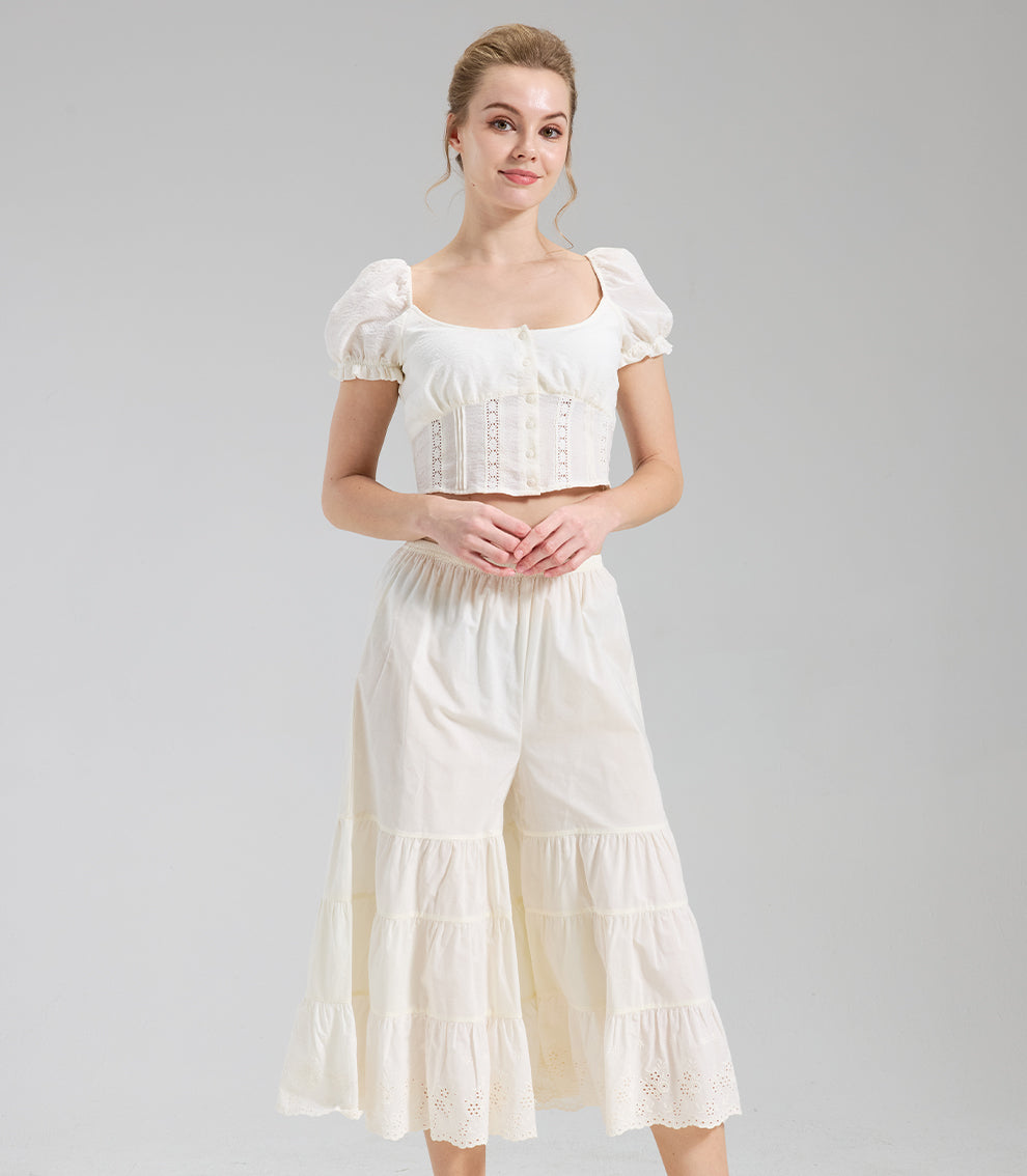 Model wearing cream cottagecore bloomers with tiered ruffles and eyelet lace for a feminine vintage aesthetic.