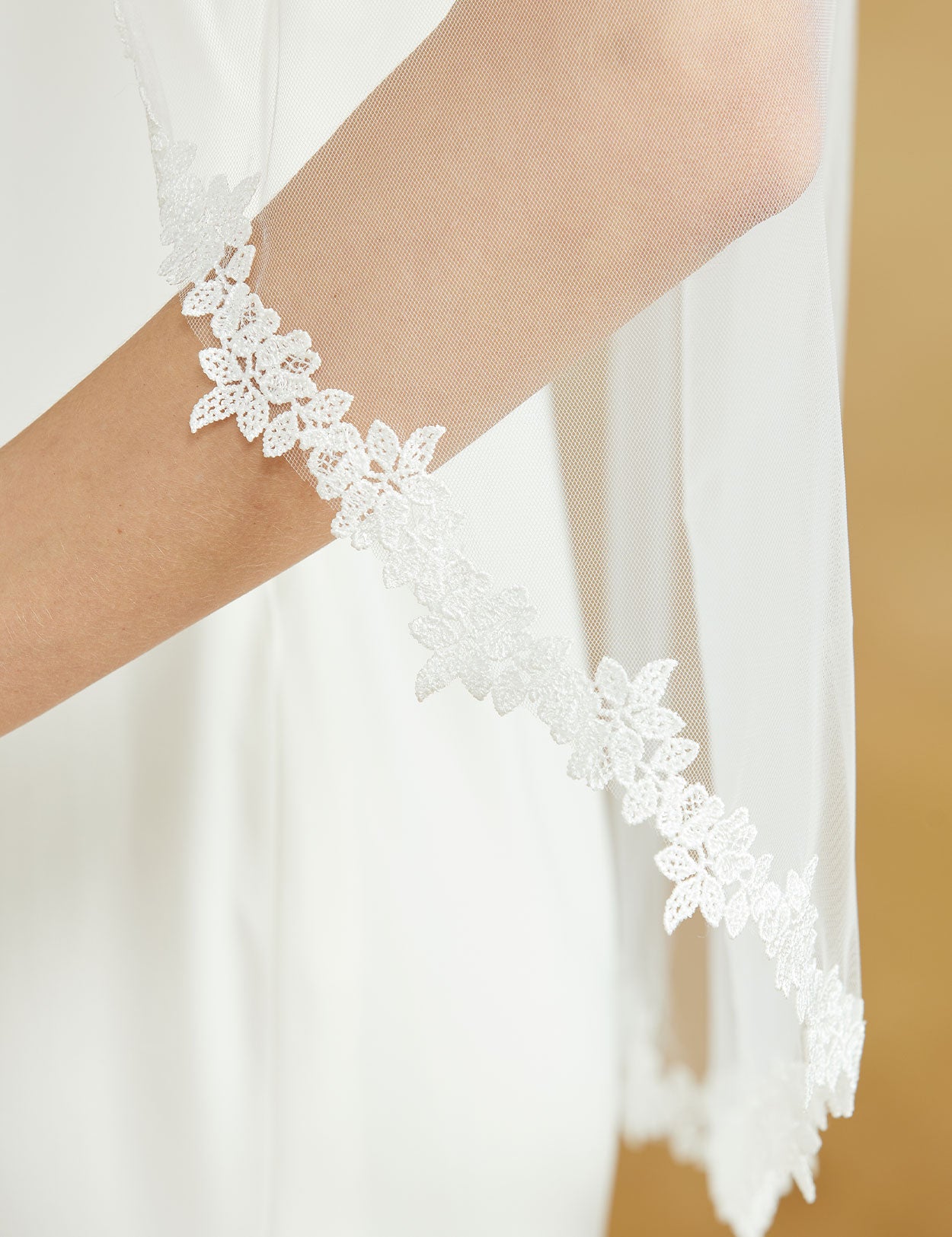 Fingertip length wedding veil with delicate lace applique edge and comb