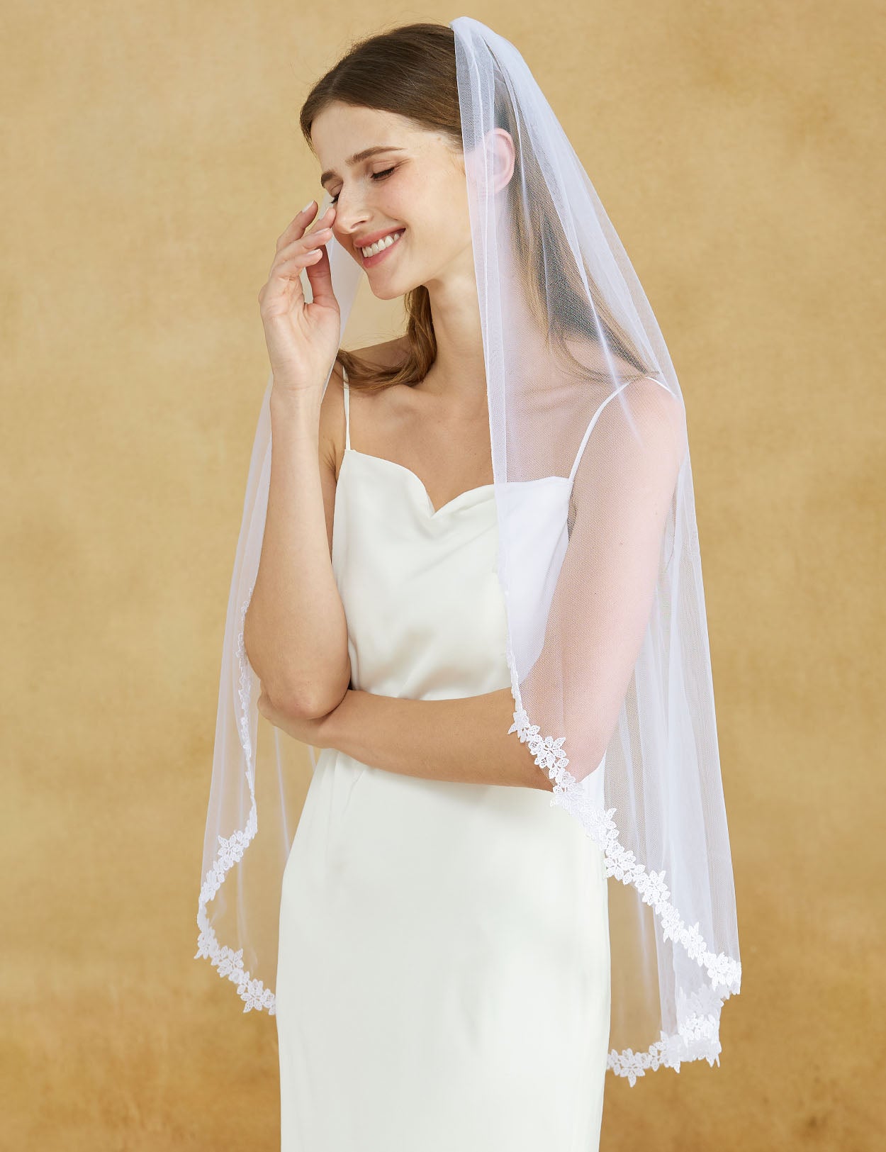 Fingertip length wedding veil with delicate lace applique edge and comb