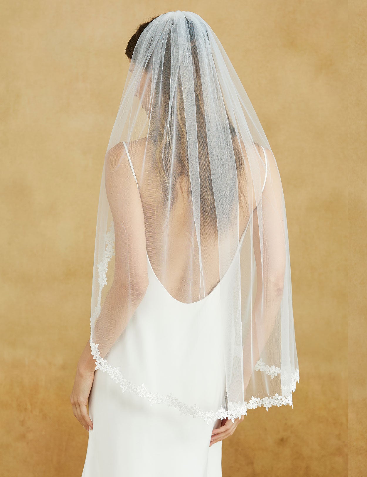 Fingertip length wedding veil with delicate lace applique edge and comb