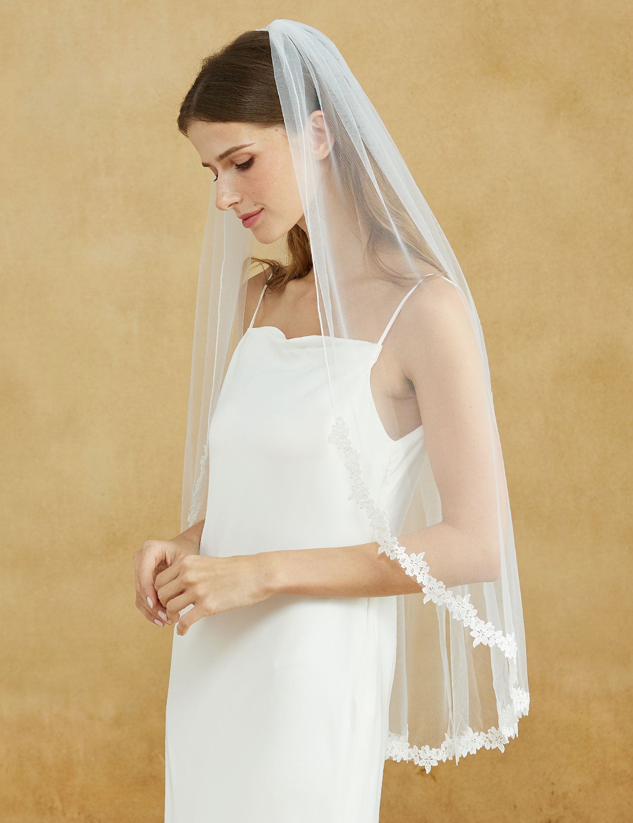 Fingertip length wedding veil with delicate lace applique edge and comb