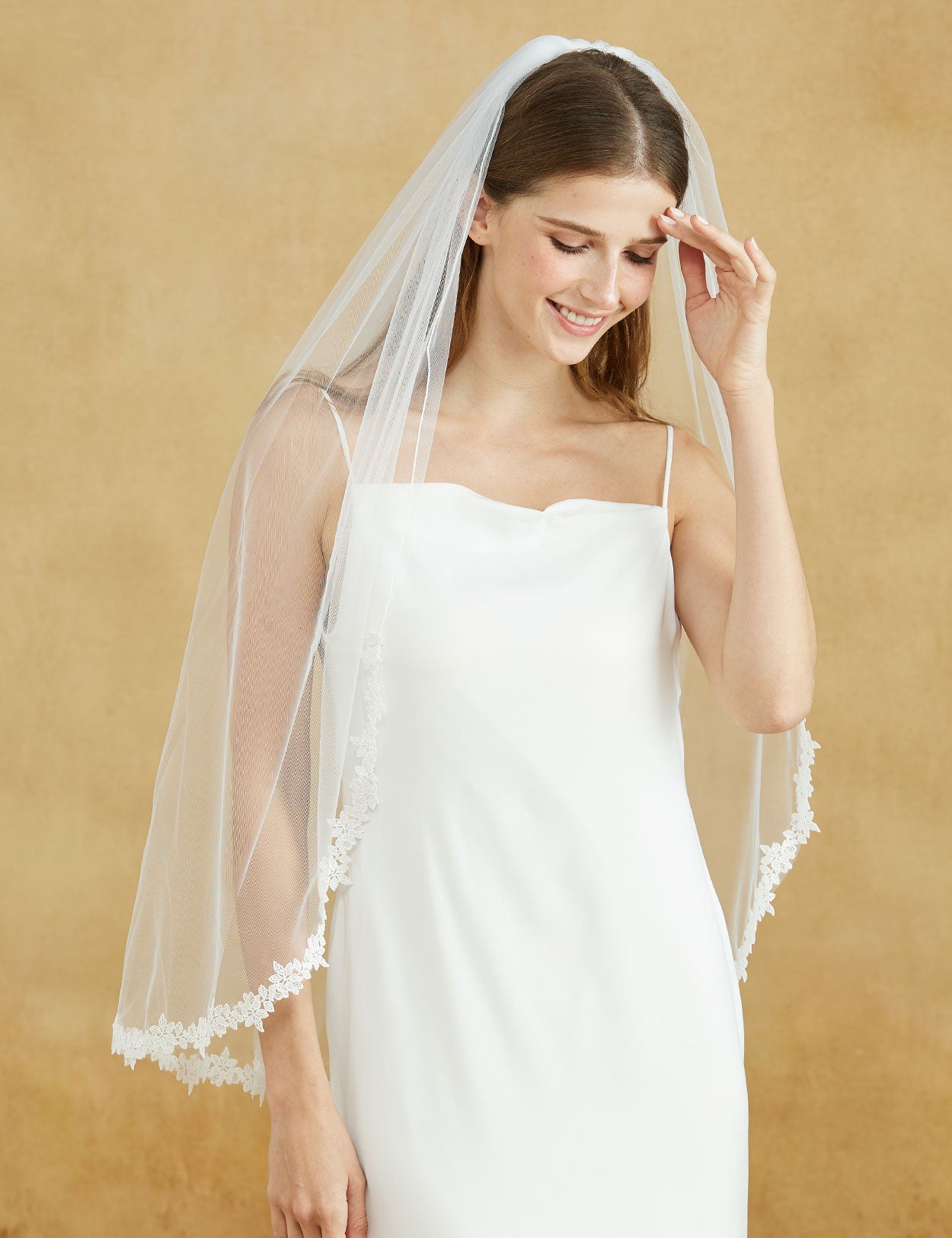 Fingertip length wedding veil with delicate lace applique edge and comb