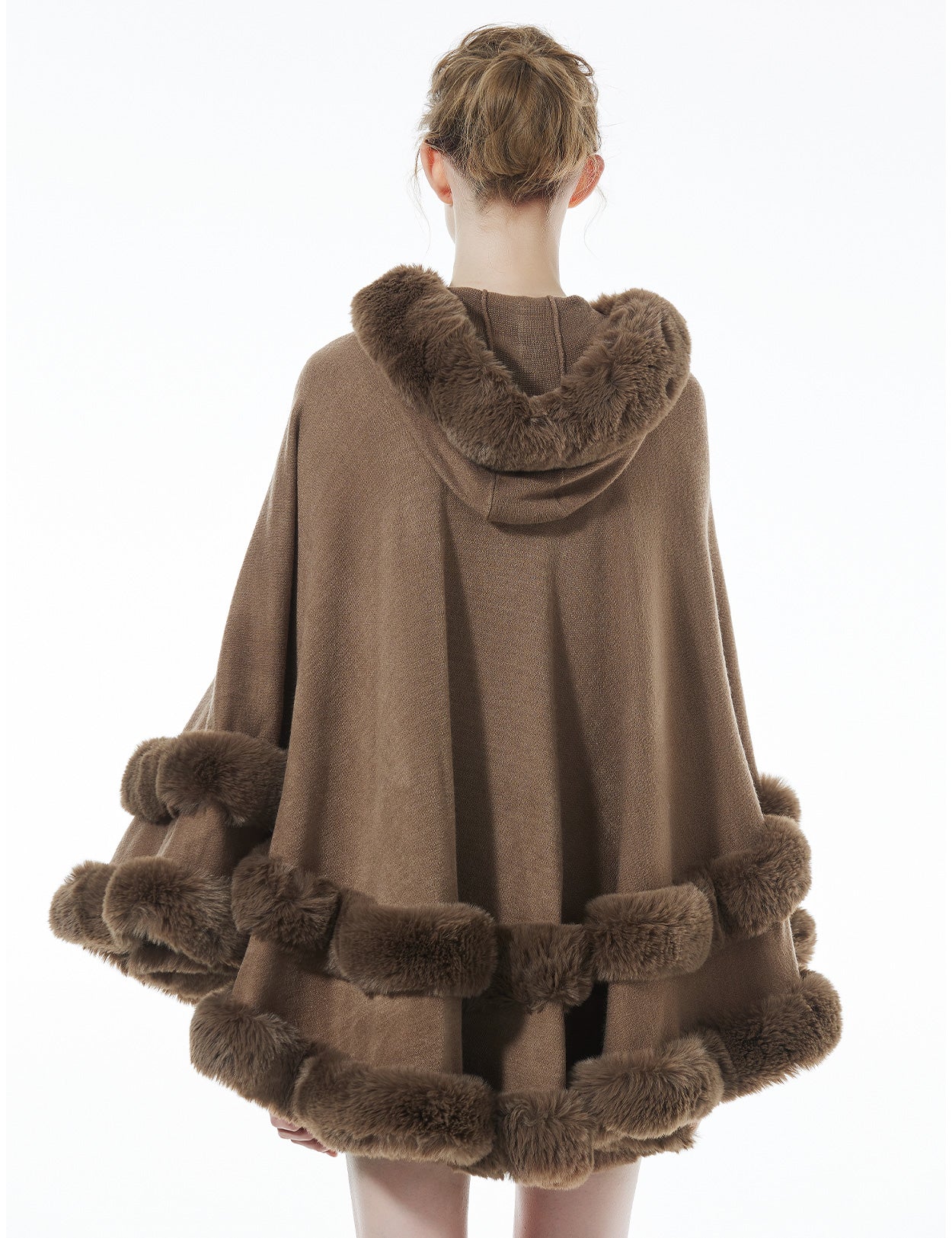 Back view of khaki hooded knit cape displaying flowing silhouette and faux fur hood detail
