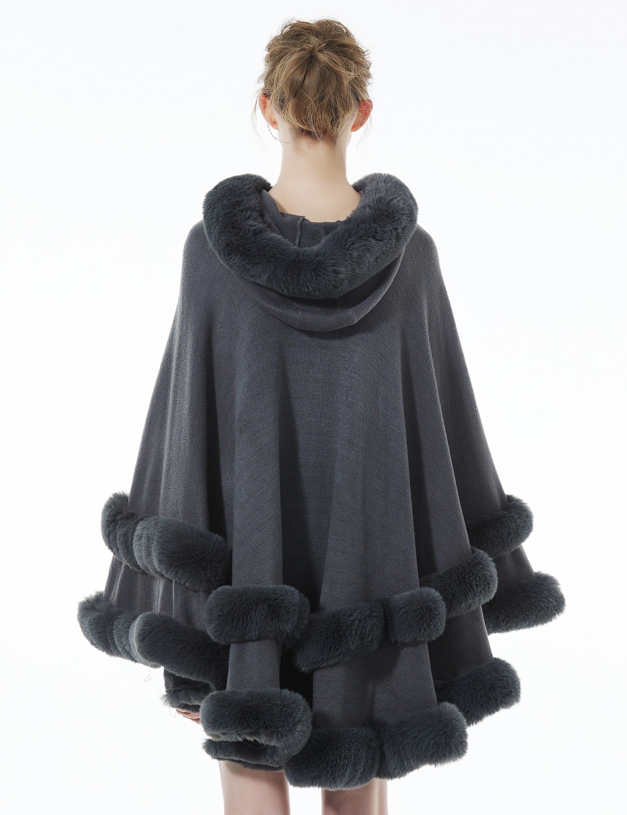 Back view of stonegrey hooded knit cape displaying flowing silhouette and faux fur hood detail