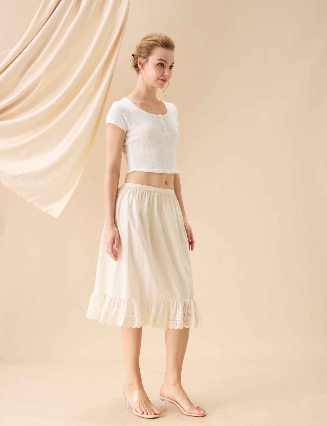 Full length view of a vintage cream cotton half slip with ruffle hem.