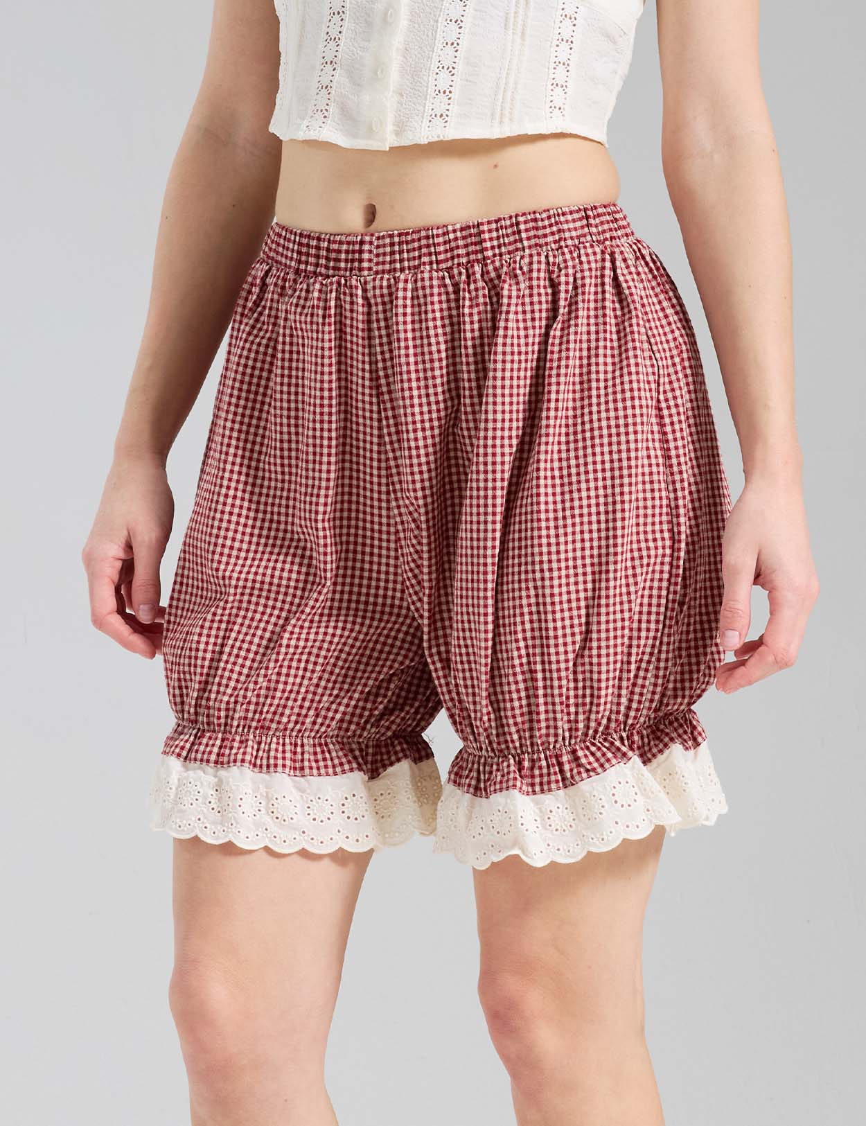 Close-up of Beautelicate Vintage Red Gingham pumpkin pants showing eyelet lace cuff and elastic waistband detail