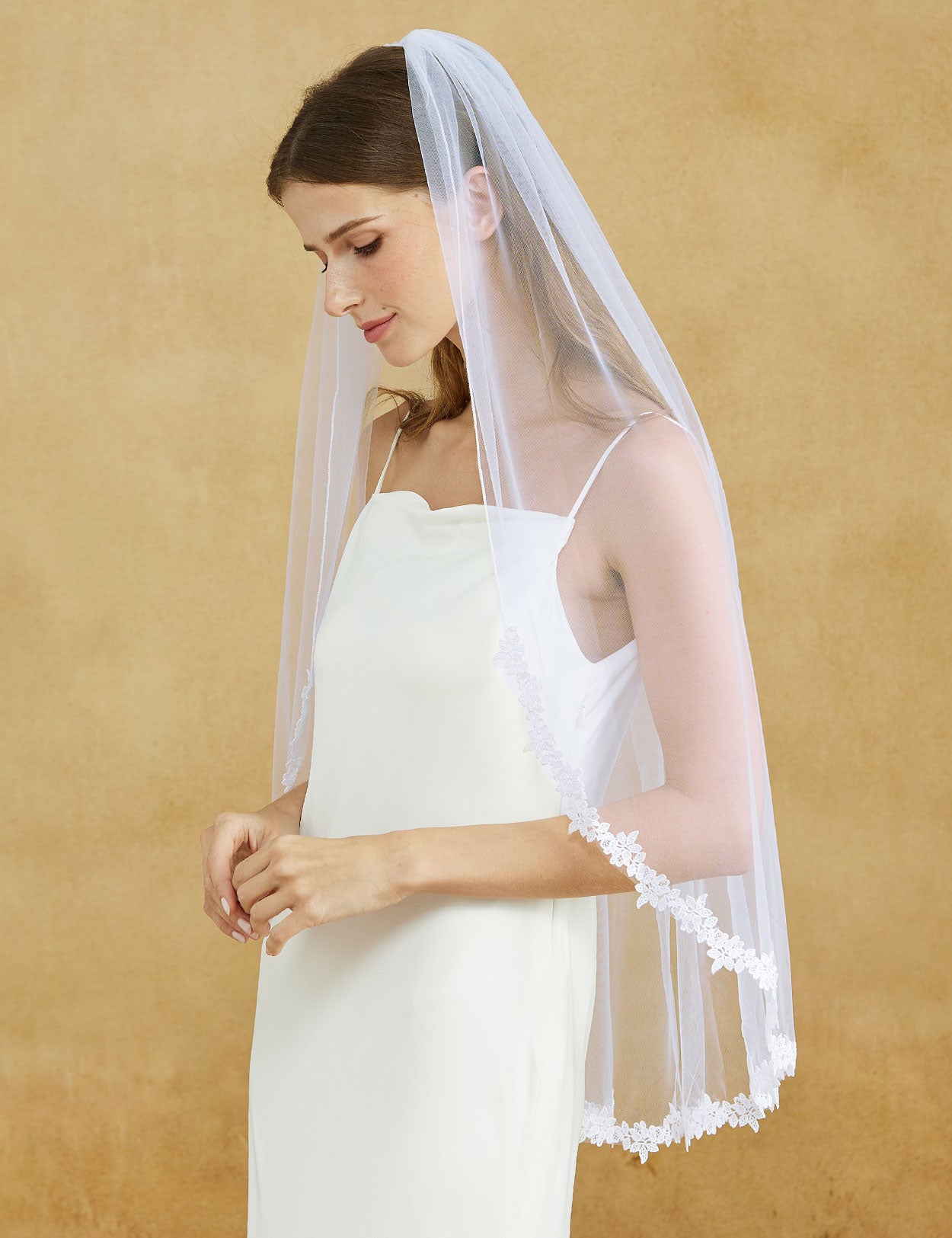 Fingertip length wedding veil with delicate lace applique edge and comb
