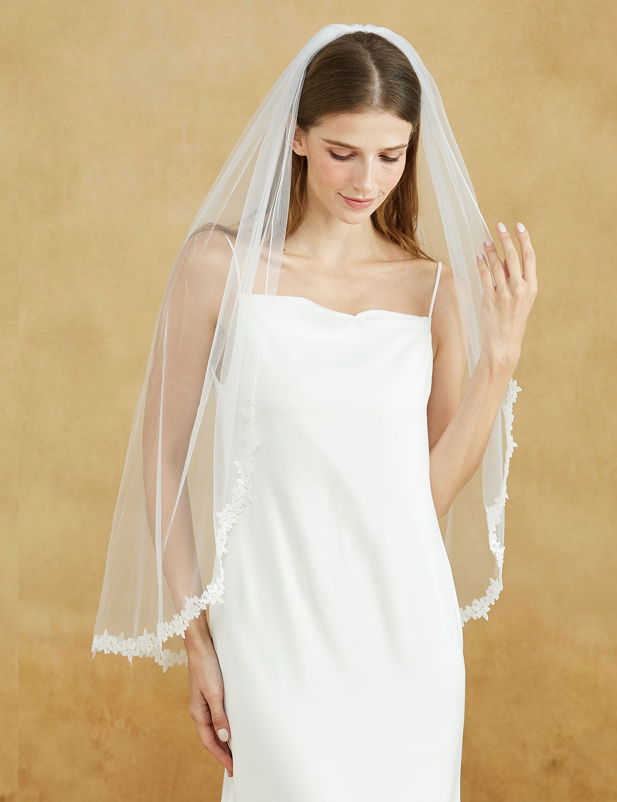 Fingertip length wedding veil with delicate lace applique edge and comb
