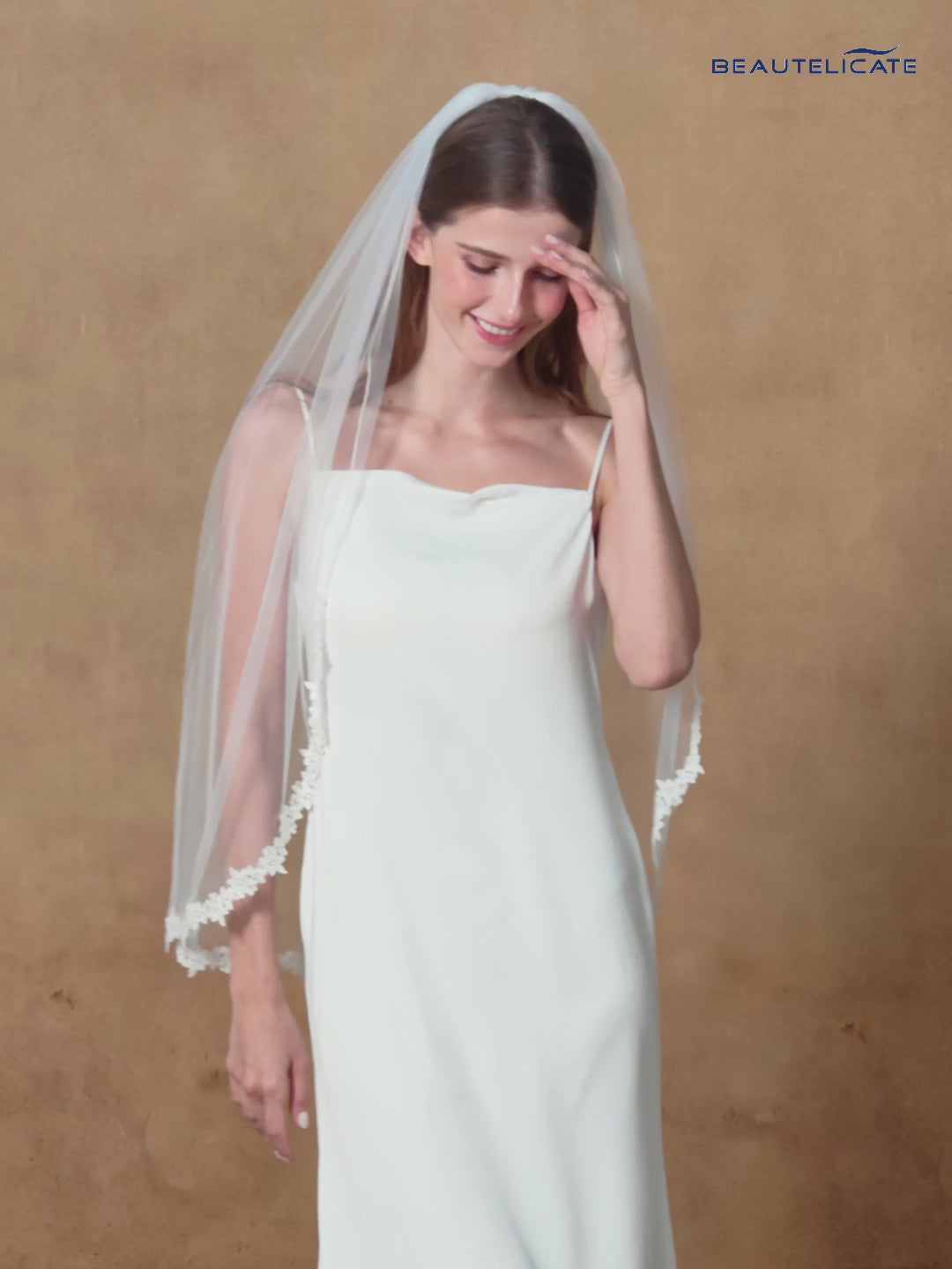 Fingertip length wedding veil with delicate lace applique edge and comb