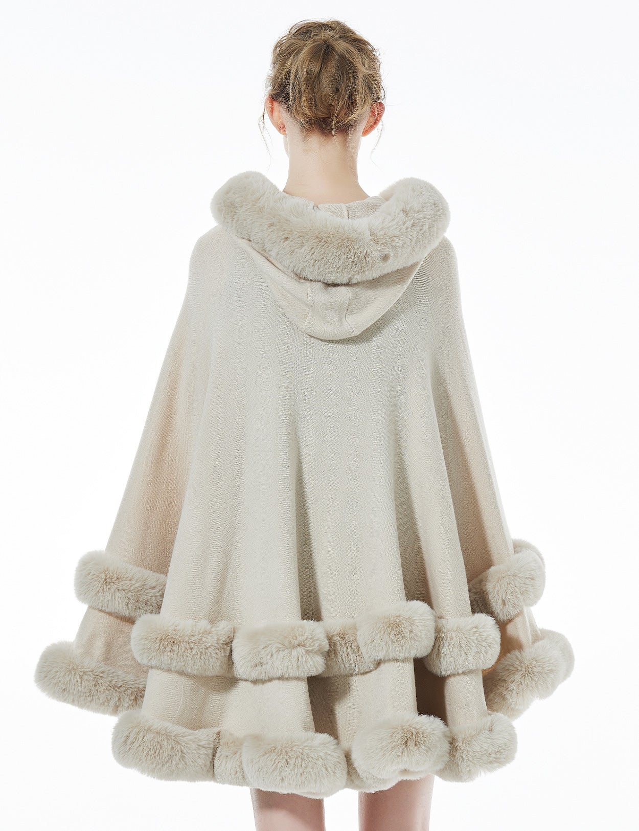 Women's beige hooded knit cape back view showing faux fur trim and flowing silhouette