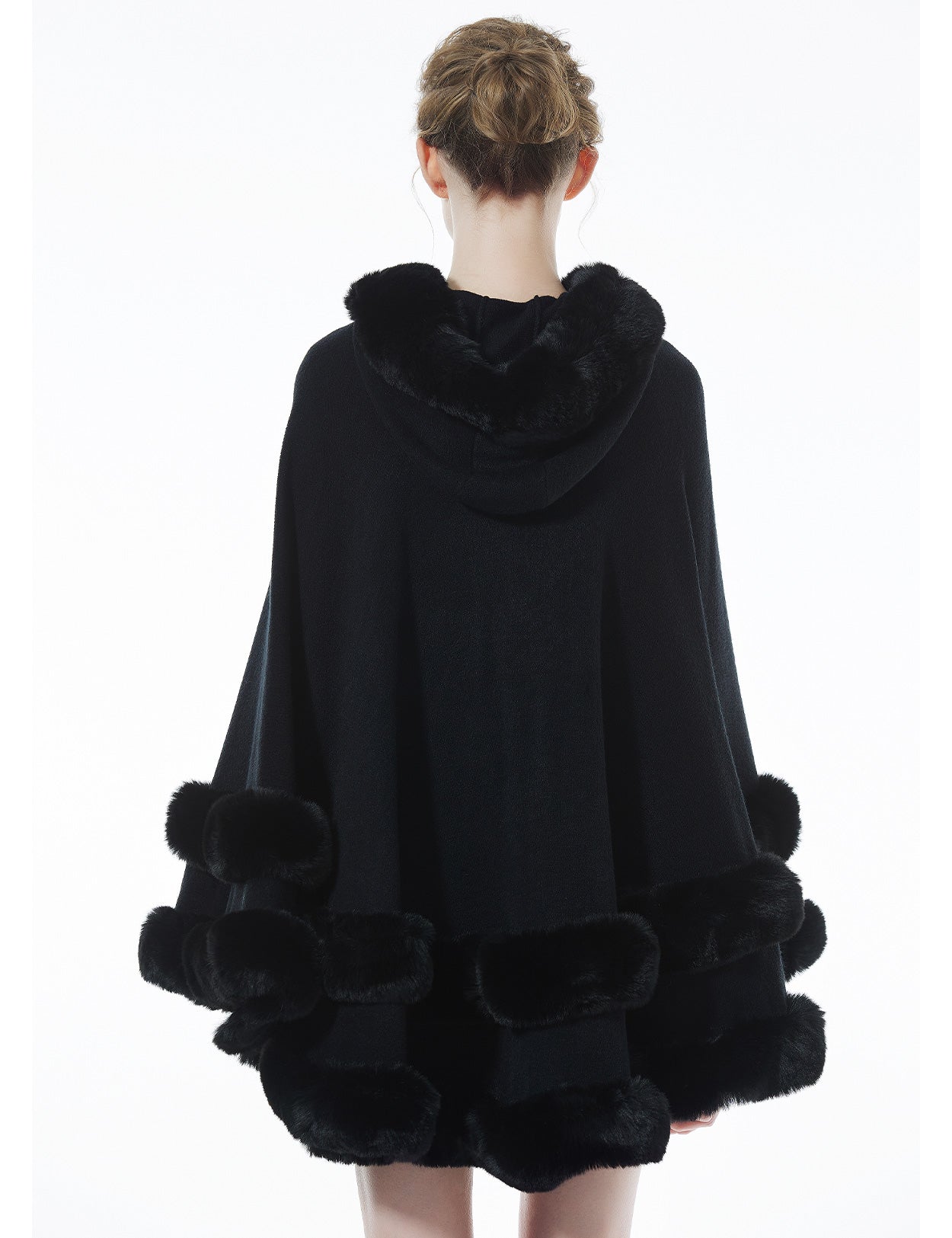 Women's black hooded knit cape back view showing faux fur trim and flowing silhouette