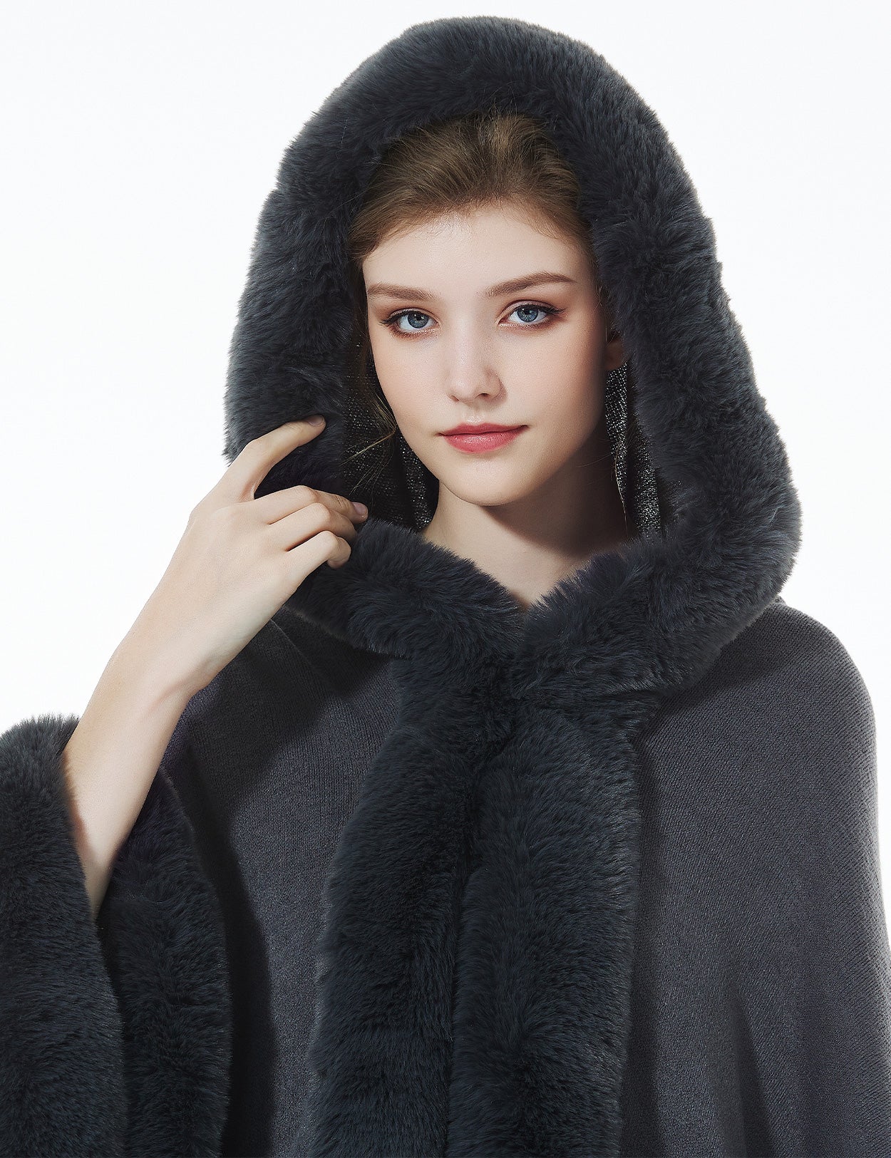 Detailed close-up of stonegrey knit cape's oversized hood with luxurious faux fur lining