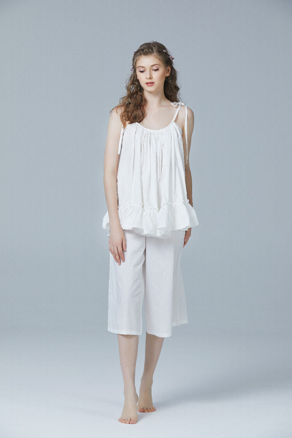 Women's cotton pajama set featuring sleeveless camisole and capri pants in comfortable loungewear style